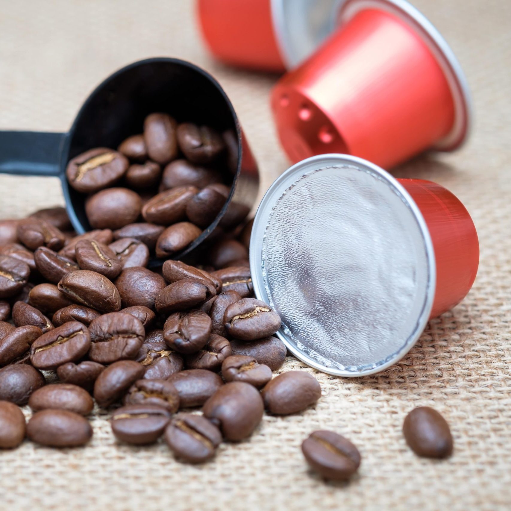 Coffee beans laying among K-cups
