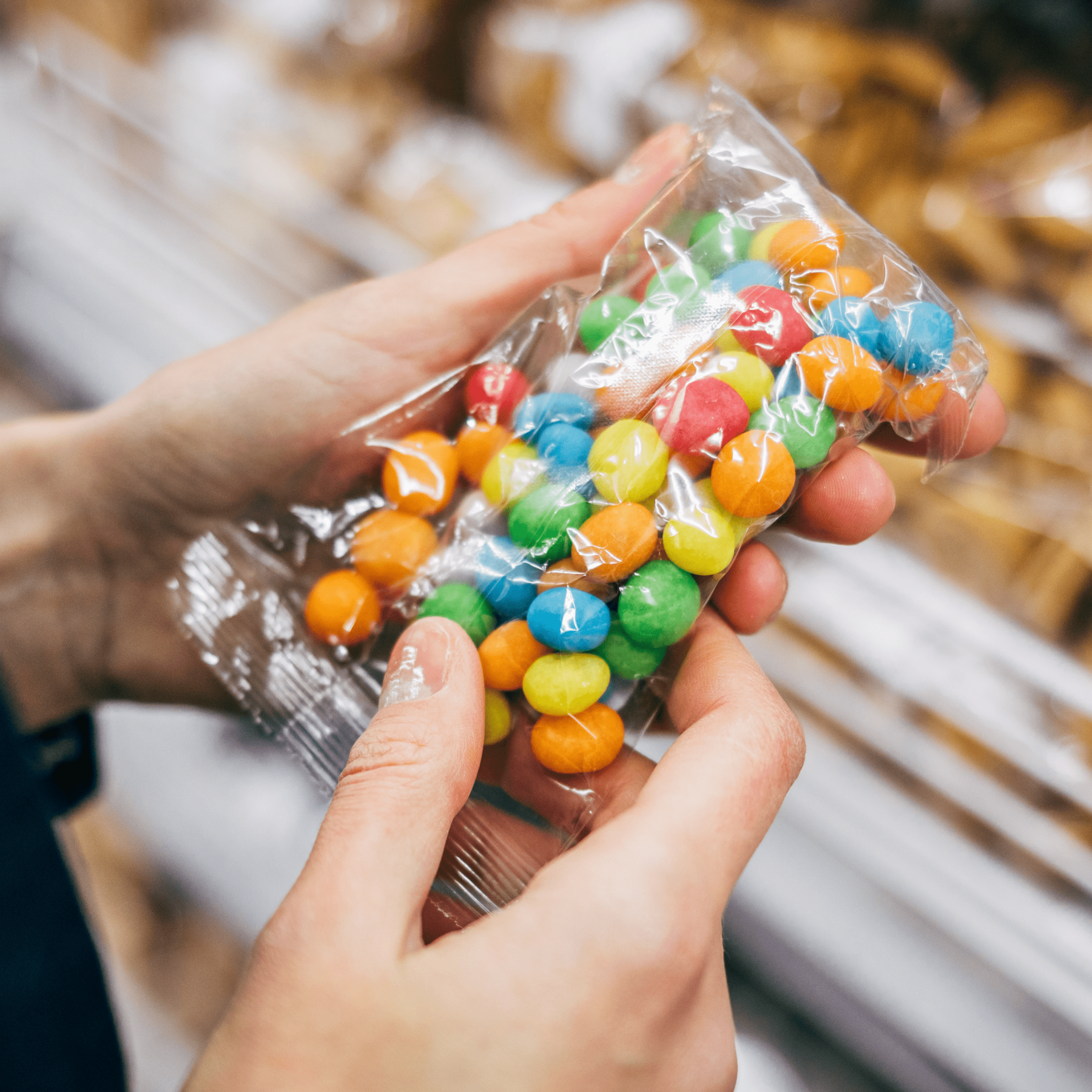 A pair of hands holding a bag of candy