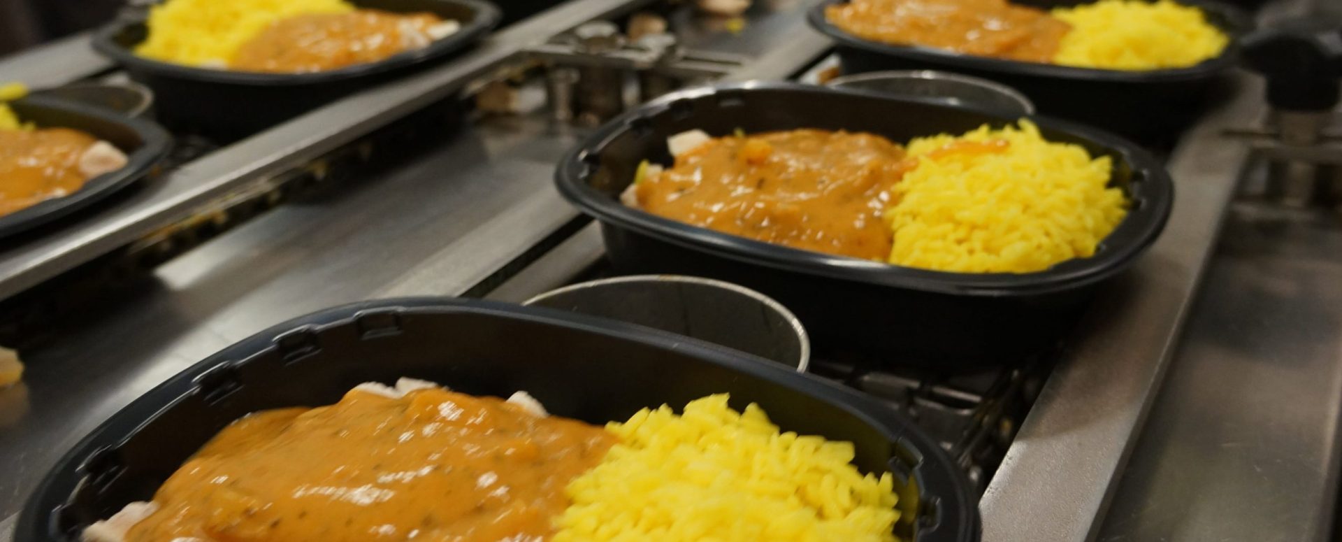 Several ready meals being packed on an assembly line